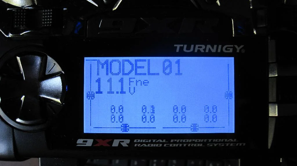 Аппаратура радиоуправления Turnigy 9XR с прошивкой ER9X включена. На экране отображаются положение джойстиков и напряжение аккумулятора 11.1V.