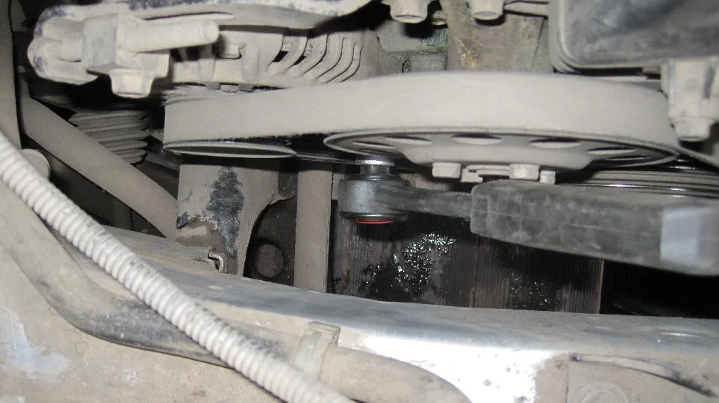 Процесс ослабления ремня привода генератор Mitsubishi Lancer IX ключом трещотка.