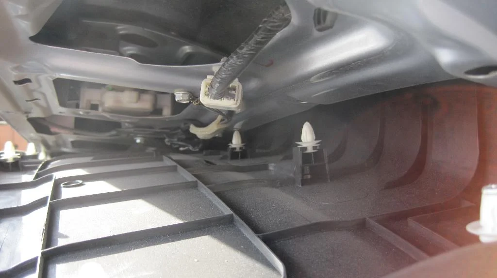 Пластиковая накладка крышки багажника Mitsubishi Lancer IX Wagon наполовину снята. Вид на защелки изнутри.