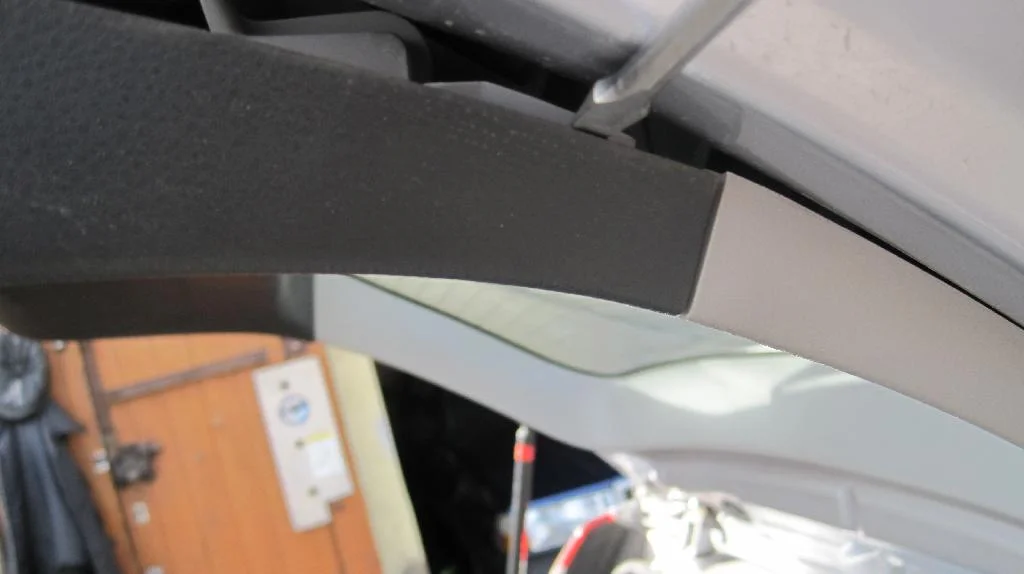 Пластиковая накладка крышки багажника Mitsubishi Lancer IX Wagon подевается сбоку отверткой в районе крепление к обшивке вокруг стекла.
