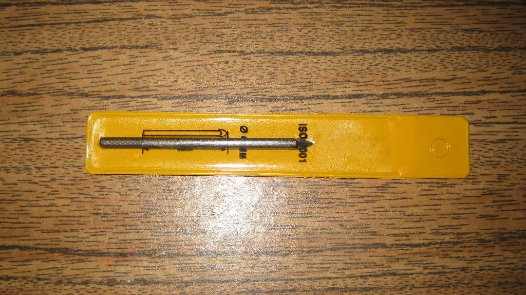 Сверло по плитки/стеклу 6 мм в желтой упаковке лежит на столе.