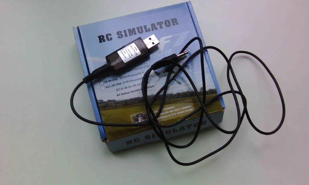 Упаковка USB RC Simulator и сам кабель лежат на столе.