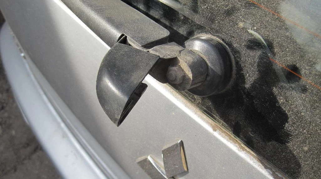 Задняя щетка стеклоочистителя Mitsubishi Lancer IX Wagon со снятым колпачком. Гайка крепления вся в пыли и грязи.