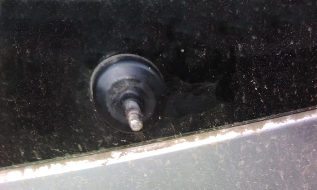 Защитная крышка надета на вал стеклоочистителя заднего стекла Mitsubishi Lancer IX Wagon. Заднее стекло в пыле и грязи.