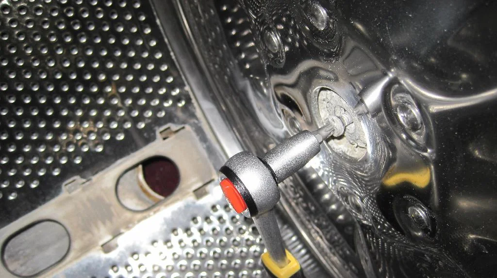 Стиральная машина ARDO TL1000X, пластиковая заглушка внутри барабана снята, откручивание при помощи шестигранника болта крепления барабана