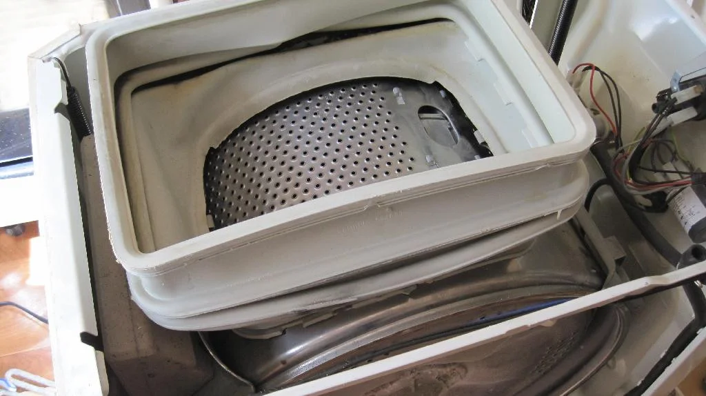 Верхняя часть стиральной машины ARDO TL1000X снята, осталась только уплотнительная резинка прикрепленная на герметик к баку