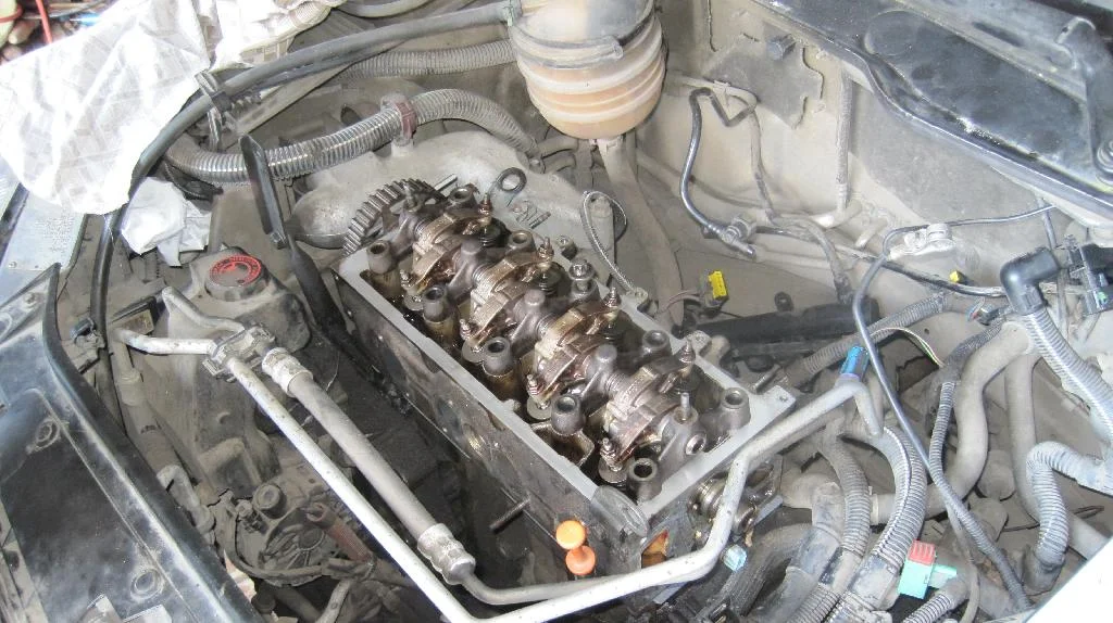 Болт крепления ГБЦ вставлен в двигатель TU3JP, коромысло клапанов установлено на головку блока цилиндров