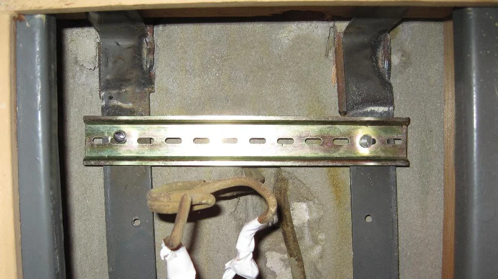 Верхняя DIN-рейка прикручена двумя винтами к каркасу электрощита