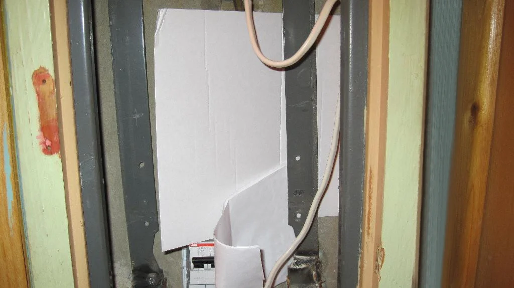 Вводной автомат закрыт картонками, в каркасе электрощита отмечены места под отверстия