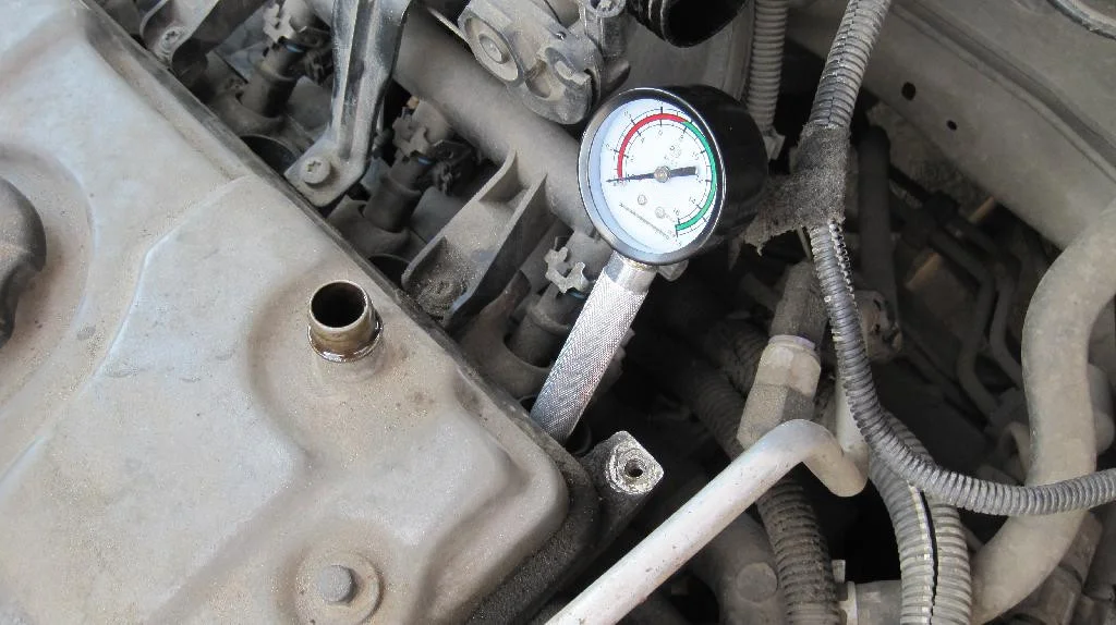 Измерение компрессии двигателя TU3JP автомобиля Peugeot 206, компрессометр вставлен в свечной колодец