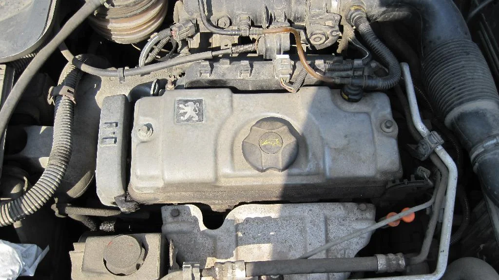 Капот автомобиля Peugeot 206 открыт и видно двигатель TU3JP