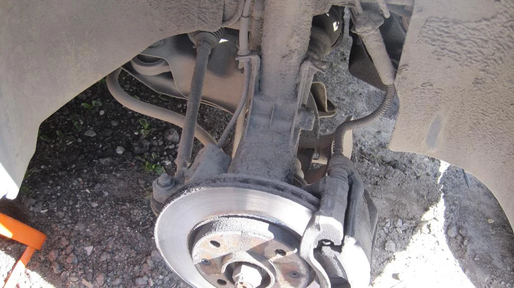 Передние правое колесо автомобиля Peugeot 206 снято, видно элементы подвески