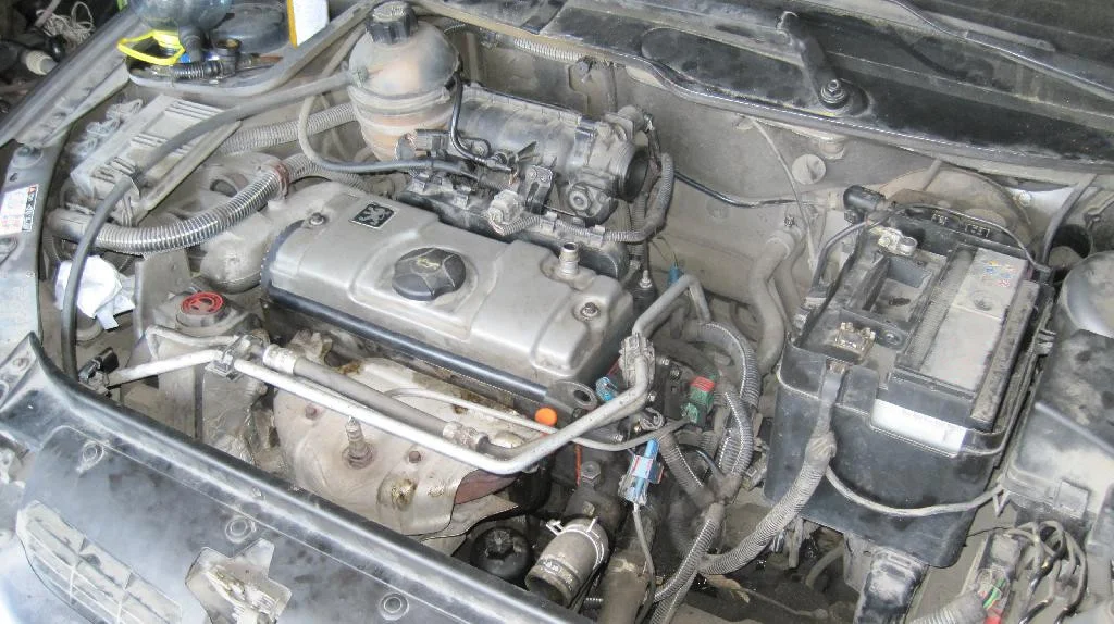 Впускной коллектор, катушки зажигания, топливная рампа установлены на двигатель TU3JP, вид под капотом автомобиля Peugeot 206