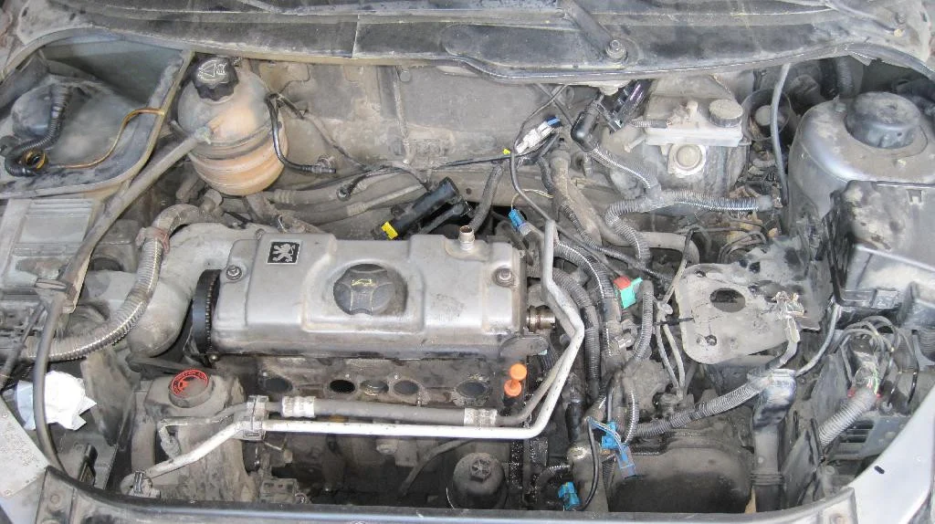 Подкапотное пространство Peugeot 206, двигатель TU3JP частично разобран, сняты впускной и выпускной коллектор, снят аккумулятор с корпусом и радиатор охлаждения